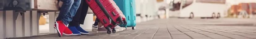 Travelers with suitcases waiting at a bus station